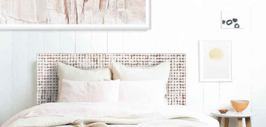 Light and airy bedroom with wooden white washed headboard